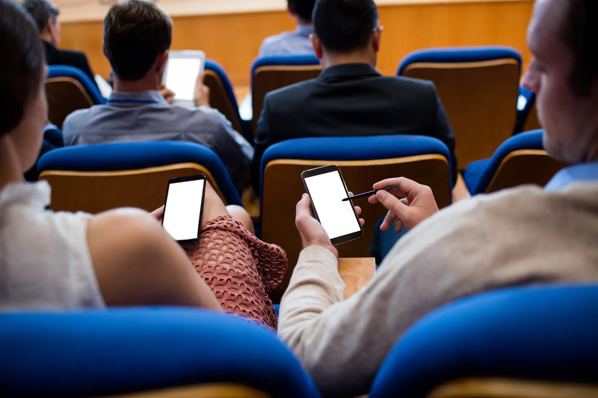 Führungskräfte, die mithilfe eines Mobiltelefons an einer Geschäftsbesprechung teilnehmen.